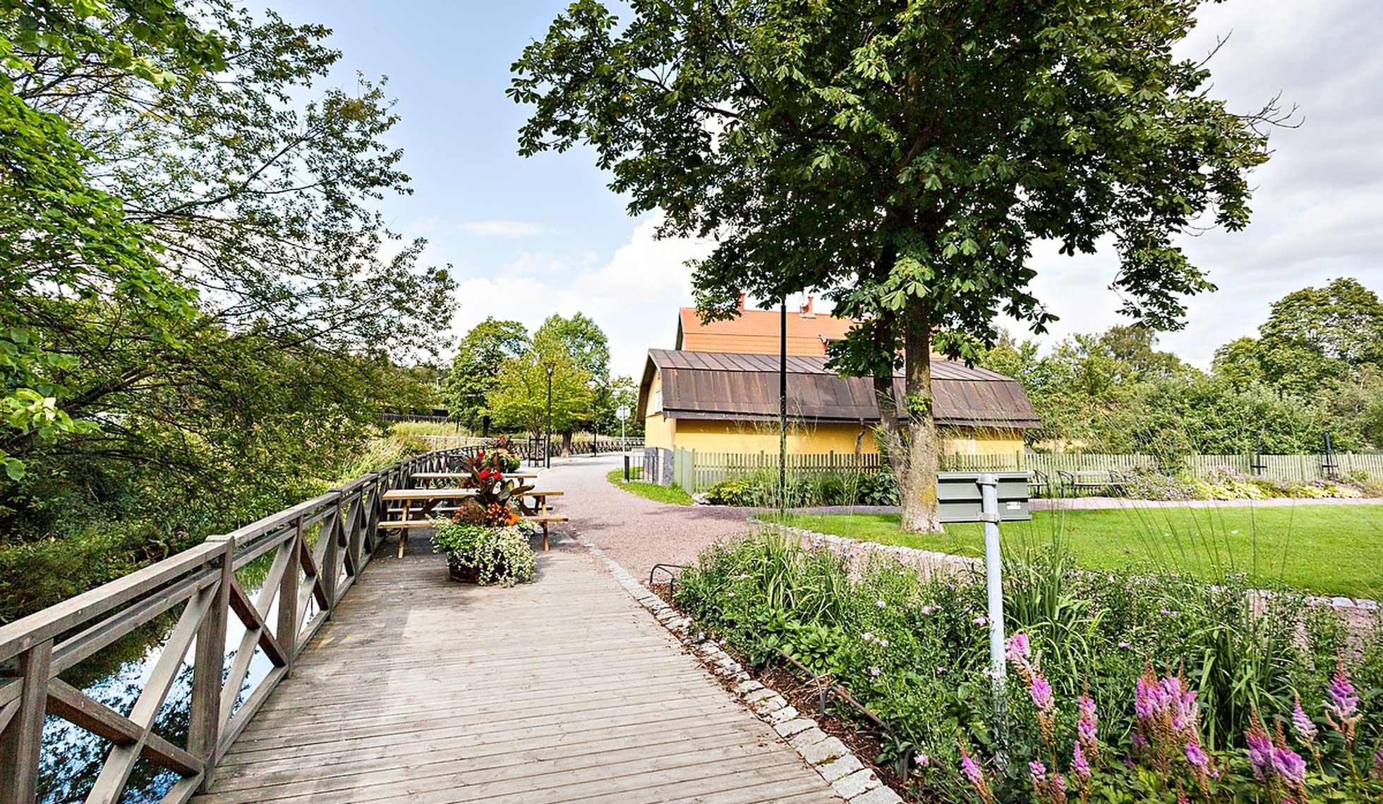 Promenadstråk kantat av rabatter och bänkar längs med Väsbyån.