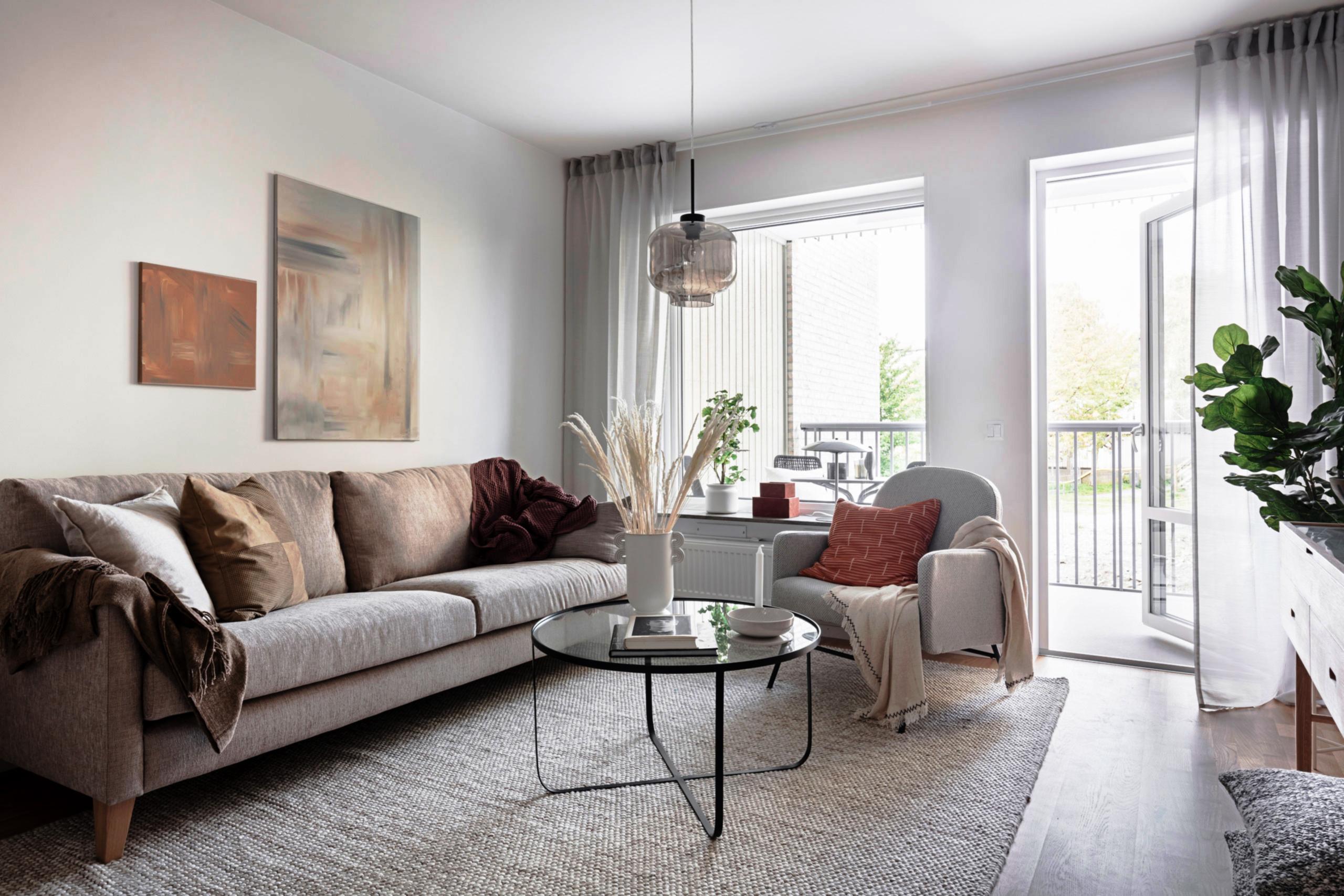 Ljust vardagsrum med öppen balkongdörr.