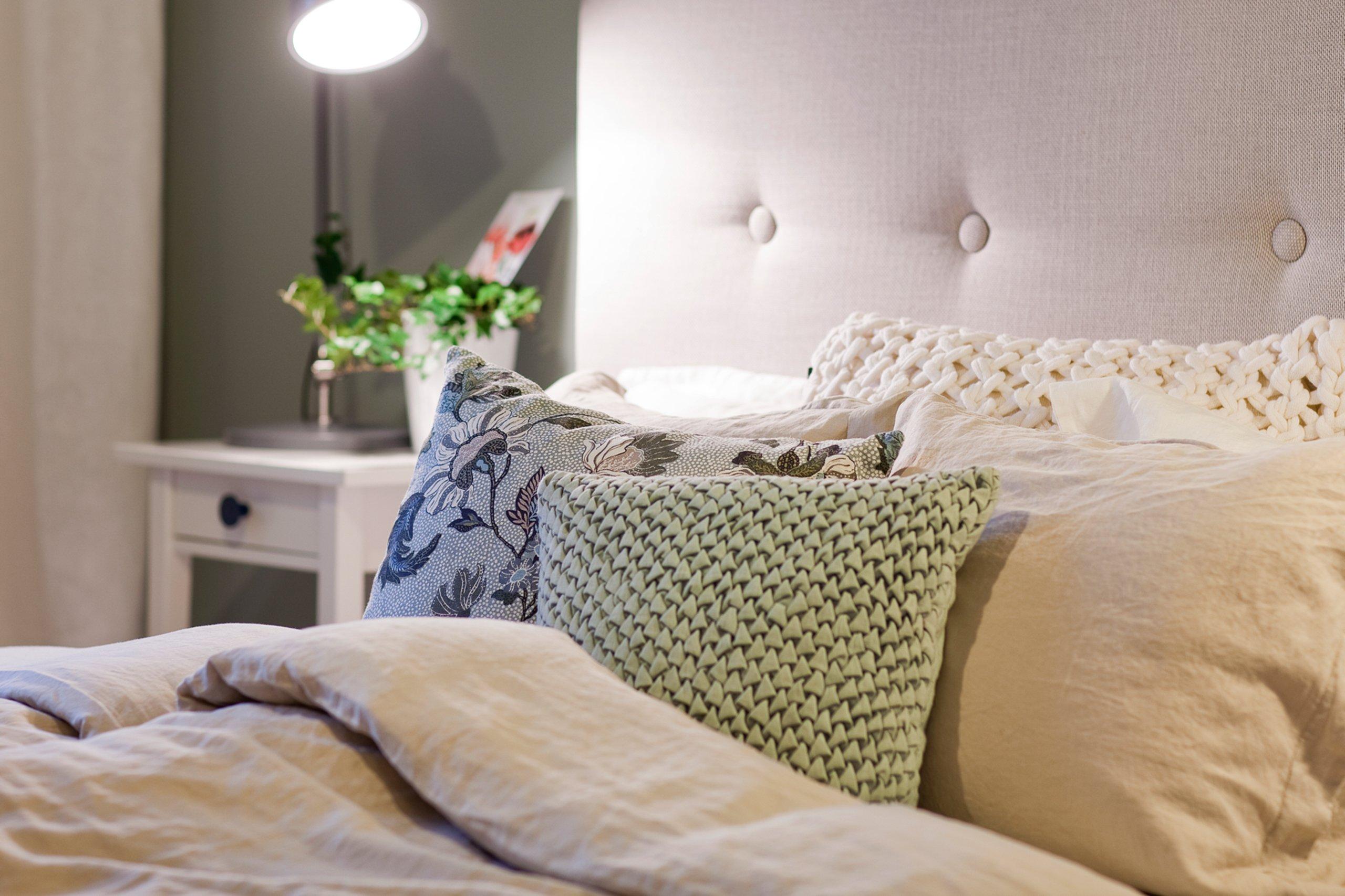 Bäddad säng med många kuddar.