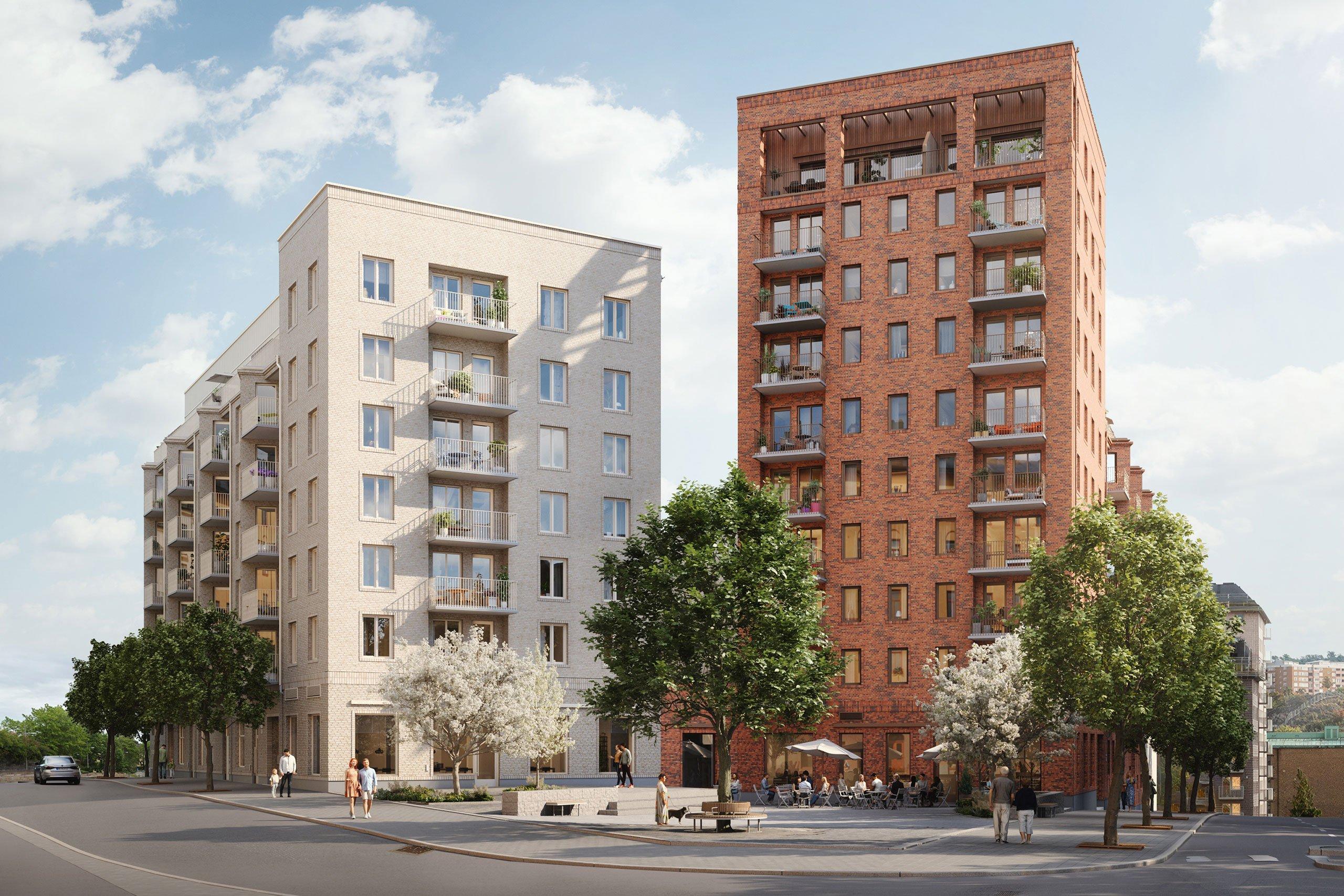 Kvartersfasader intill torg med blommande träd. 