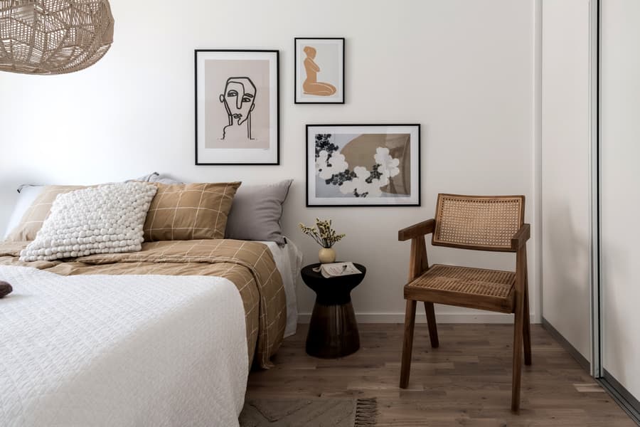 Sovrum i vitt med rottingmöbler.