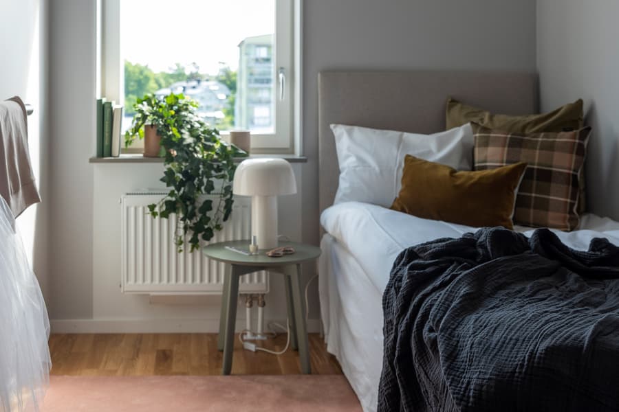 Mindre sovrum med bäddad säng.